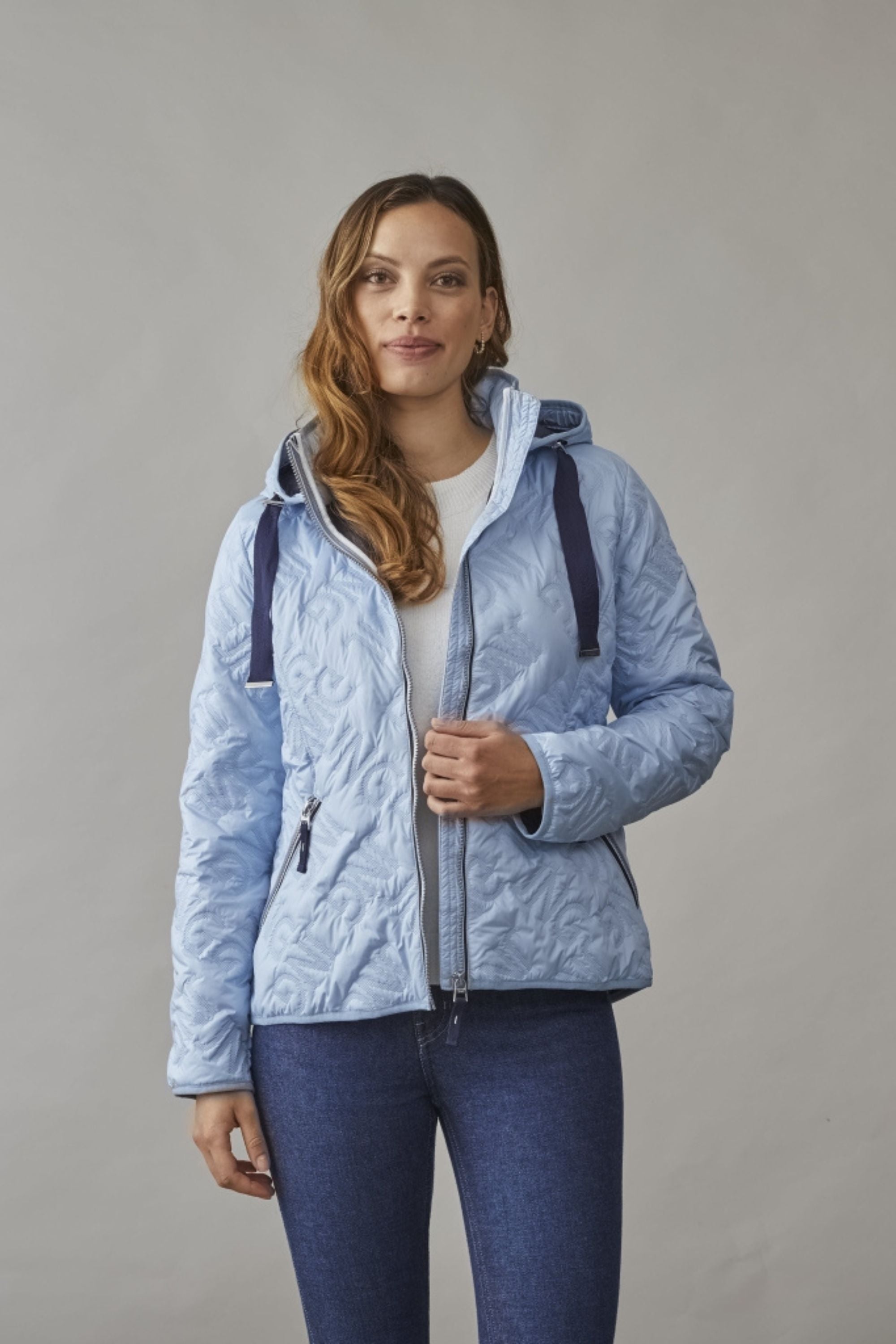 Woman wearing a stylish women's spring jacket in pastel blue with quilted details, perfect for a fresh and lightweight spring look.